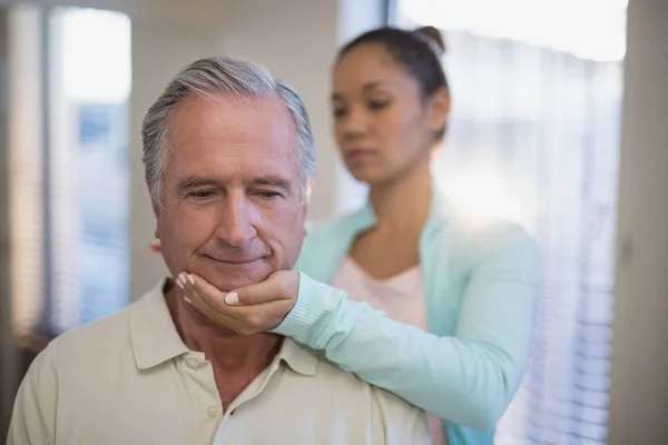 Therapeutin gibt Seniorin Nackenmassage — Stockfoto