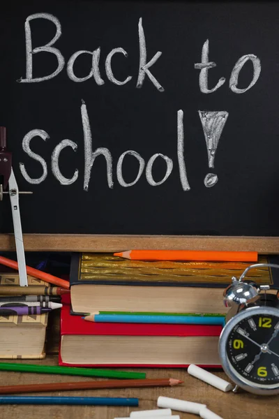 Alarm clock with pencils and slate — Stock Photo, Image