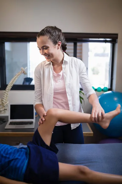 Terapeuta examinando pierna de niño — Foto de Stock