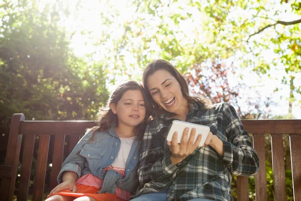 Mujer mostrando teléfono móvil a hija —  Fotos de Stock