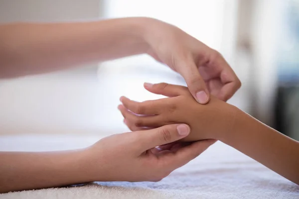 Therapeut onderzoeken hand op witte handdoek — Stockfoto