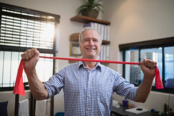 Patiënt trekken rode elastische band — Stockfoto