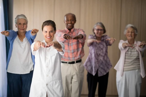 Sorridente medico femminile e anziani che esercitano — Foto Stock