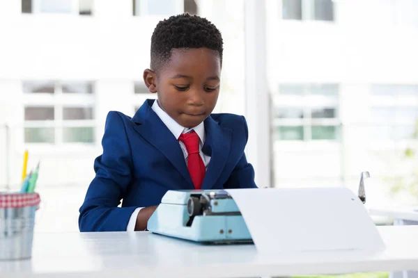 Бизнесмен, использующий пишущую машинку за столом — стоковое фото