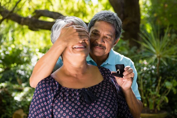 Hombre mayor cubriendo ojos de mujer — Foto de Stock