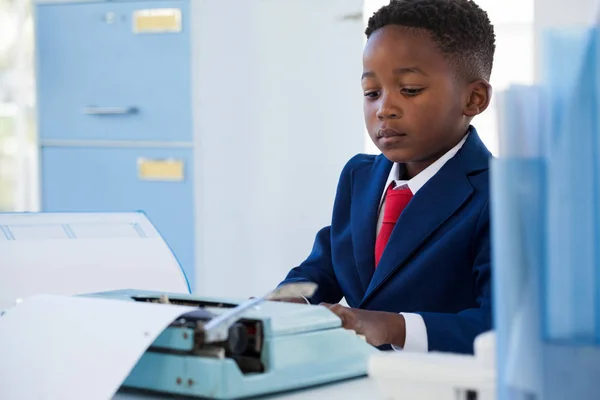 Boy imitující jako podnikatel pomocí psací stroj — Stock fotografie