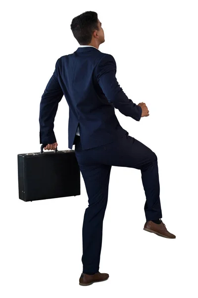 Businessman with briefcase climbing invisible steps — Stock Photo, Image