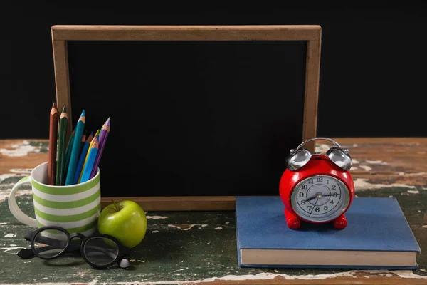 Tableau noir avec livre, pomme et lunettes — Photo