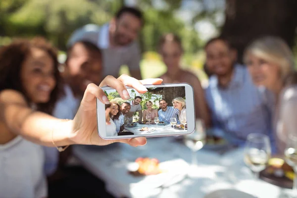 Friends taking selfie on phone while having meal — Stock Photo, Image