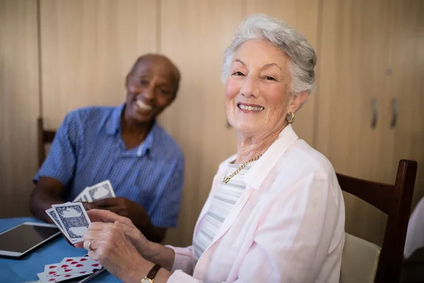Старшая женщина играет в карты с другом — стоковое фото