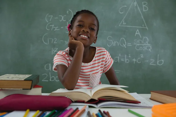 Studentessa lettura libro in classe — Foto Stock