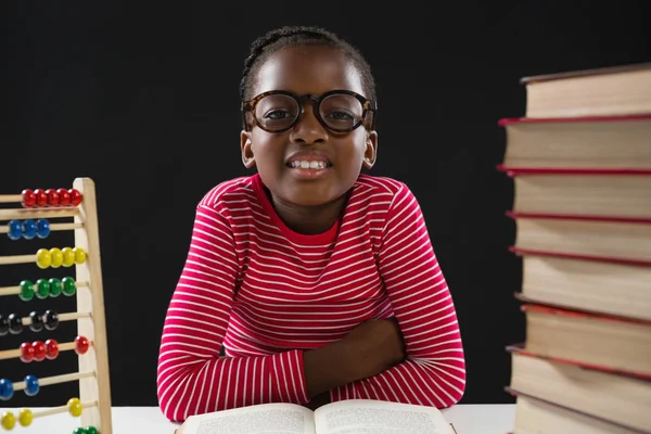 Menina bonito com ábaco e pilha de livros — Fotografia de Stock