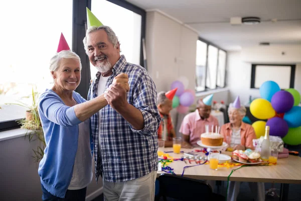 Couple senior tenant la main à la fête — Photo