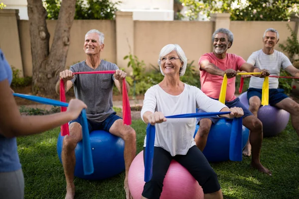 Personas mayores que escuchan al entrenador mientras hacen ejercicio — Foto de Stock
