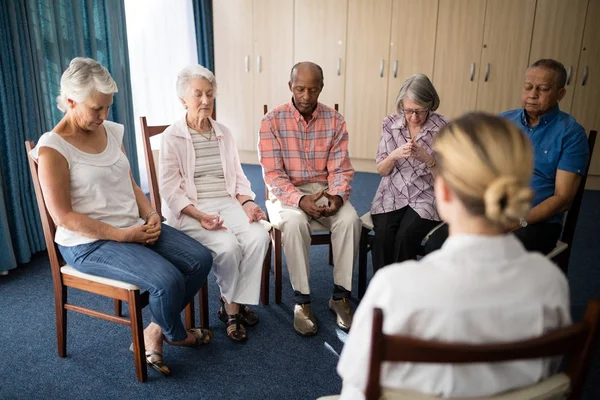 Senior people meditating with female doctor — Stock Photo, Image