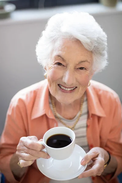 Senior vrouw bedrijf koffie beker — Stockfoto