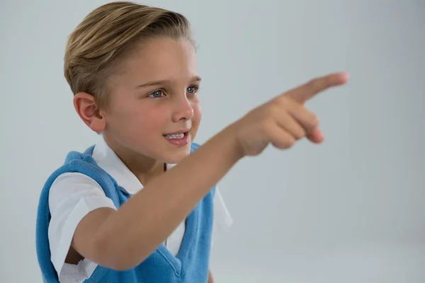 Écolier pointant doigt sur fond blanc — Photo