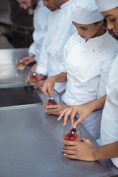 Szefowie kuchni kończąc deser w szkle w restauracji — Zdjęcie stockowe