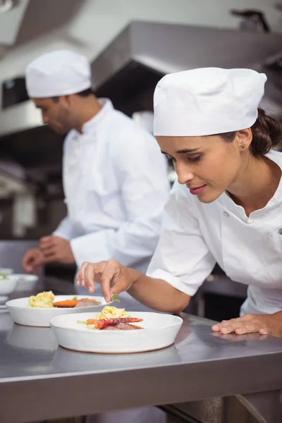 Vrouwelijke chef-kok Bijgerechten voedsel in keuken — Stockfoto