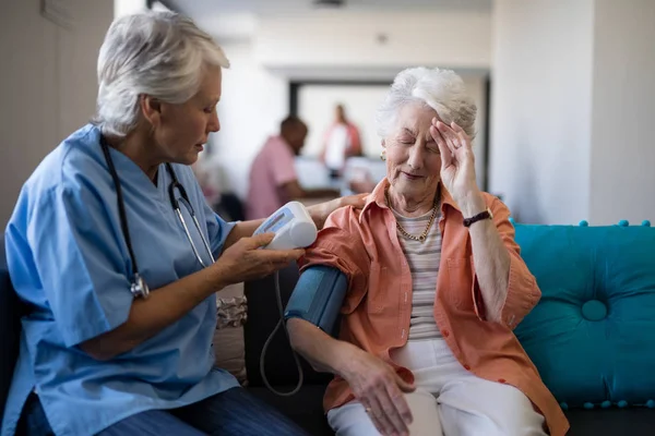 Donna anziana che si lamenta del mal di testa al medico — Foto Stock