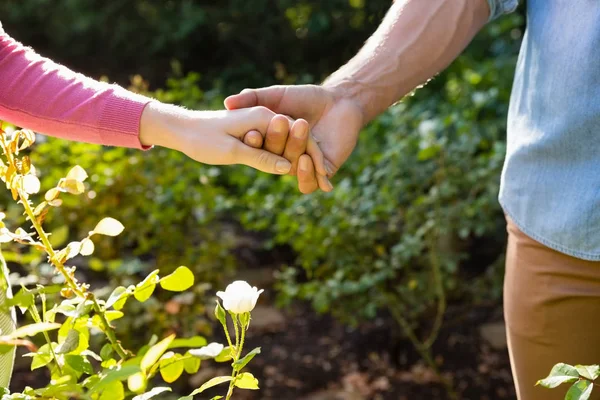 Mellersta delen av par som håller hand — Stockfoto