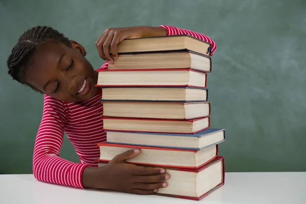 Schulmädchen sitzt mit Bücherstapel — Stockfoto