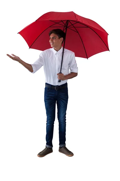 Menino de pé sob um guarda-chuva vermelho — Fotografia de Stock