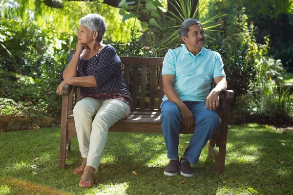 Casal sênior discutindo enquanto sentado no banco — Fotografia de Stock