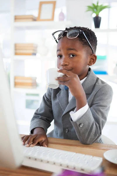 Affärsman med kopp kaffe medan du använder datorn — Stockfoto