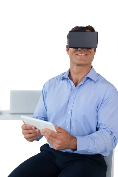 Businessman holding tablet while wearing vr glasses — Stock Photo, Image