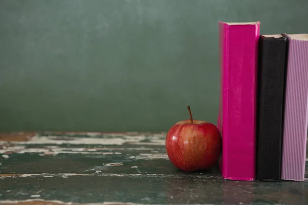 Manzana y libros sobre mesa —  Fotos de Stock