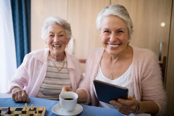 Amici anziani che prendono il caffè mentre giocano a scacchi — Foto Stock