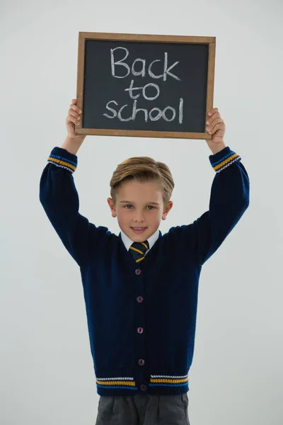 Colegial sosteniendo pizarra con texto —  Fotos de Stock