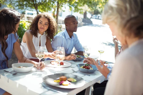 Friends interacting while having meal — Stock Photo, Image
