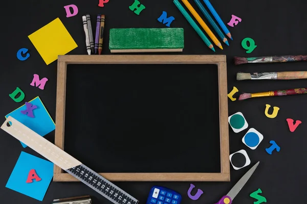Blank slate surrounded by various school supplies — Stock Photo, Image