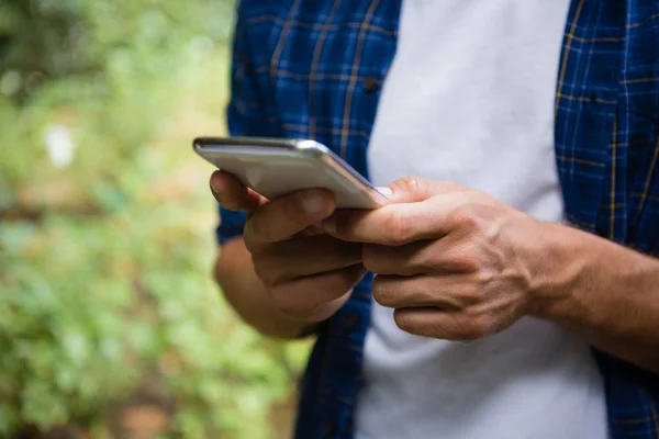 Środkową część człowieka przy użyciu telefonu komórkowego — Zdjęcie stockowe