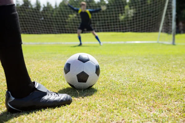Fotbollspelare med bollen mot målvakt — Stockfoto