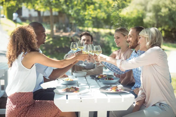 Gruppe von Freunden stößt mit einem Glas Wein an — Stockfoto