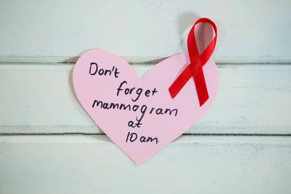 AIDS awareness ribbon on heart shape reminder — Stock Photo, Image