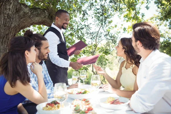 Vänner beställning till servitör — Stockfoto