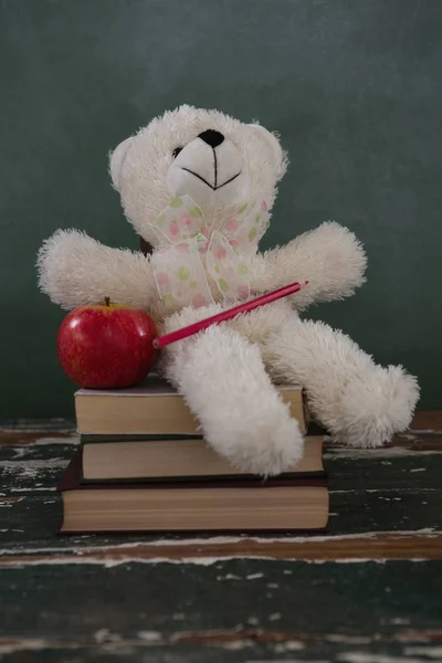 Medvídek, tužka a apple na stoh knih — Stock fotografie