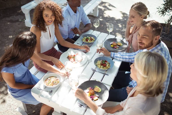 Happy vrienden interactie met elkaar terwijl het hebben van de maaltijd — Stockfoto