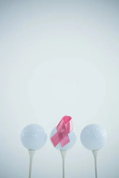 Розовая лента рака груди на мяче для гольфа — стоковое фото