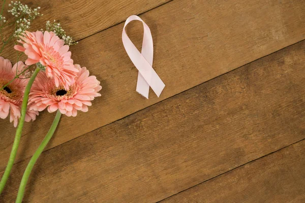 Breast Cancer Awareness ribbon by gerbera flowers — Stock Photo, Image