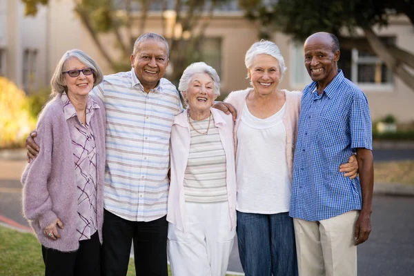 Anziani in piedi con le braccia intorno — Foto Stock