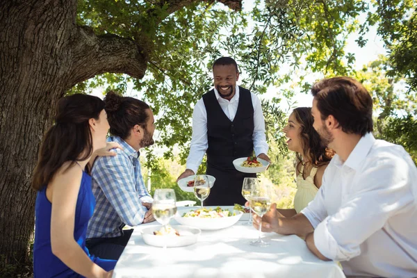 Camarero sirviendo comida a los clientes — Foto de Stock