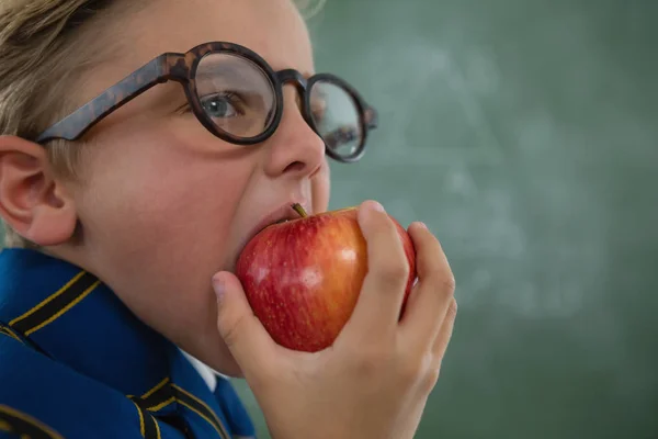 Écolier manger pomme rouge — Photo