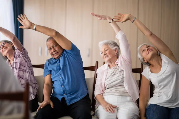 Ledande personer stretching sittande på stolar — Stockfoto