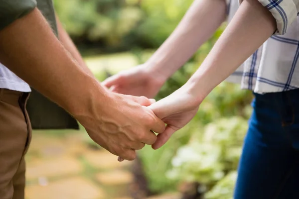 Middensectie ervan paar hand in hand — Stockfoto