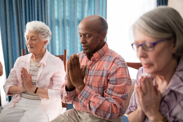 Senior man temidden van vrouwen bidden — Stockfoto